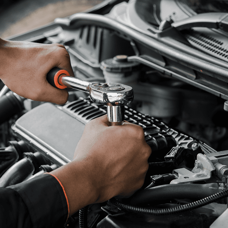 Mechanic using wrench on car engine.